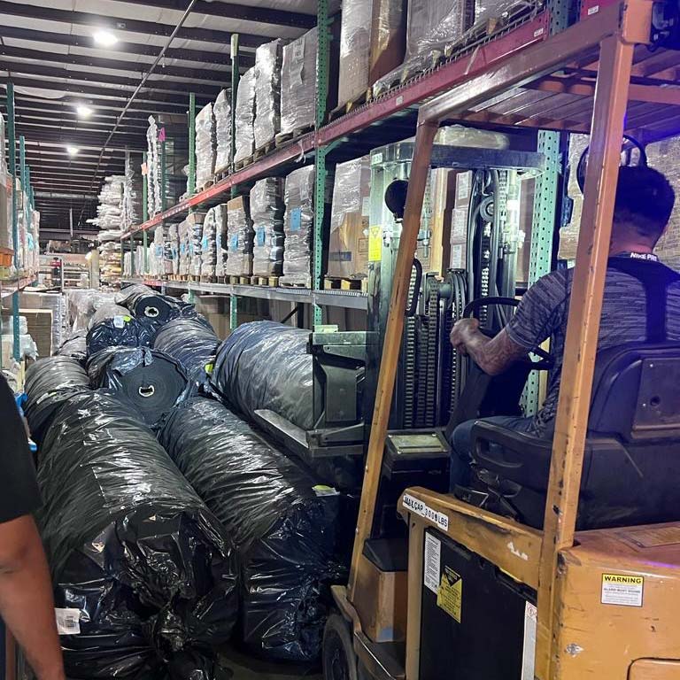 warehouse aisle with rolls of materials